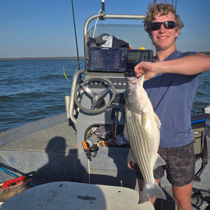 Young angler holding a striped bass on a Lake Texoma fishing trip